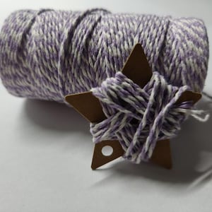Peut inclure: Un rouleau de ficelle rayée blanche et violette avec une étiquette en forme d'étoile brune.