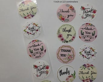 Può includere: Un rotolo di adesivi rotondi da 2,5 cm di diametro con diversi motivi floreali e il testo "Grazie" in diversi stili. Gli adesivi sono su uno sfondo trasparente.