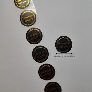May include: Roll of black and gold round stickers with the text "handmade with love" in a gold font. Each sticker is 1 inch or 2.5 centimeters in diameter.