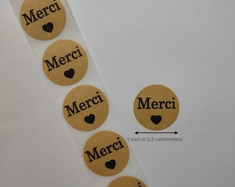 May include: Roll of brown kraft paper stickers with the word "Merci" and a small black heart printed on each sticker. The stickers are 1 inch or 2.5 centimeters in diameter.