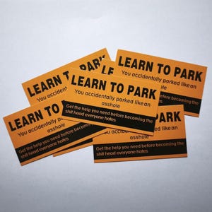 May include: Several orange rectangular cards with black text. The cards read "LEARN TO PARK" and "You accidentally parked like an asshole." The cards also say "Get the help you need before becoming the shit head everyone hates."