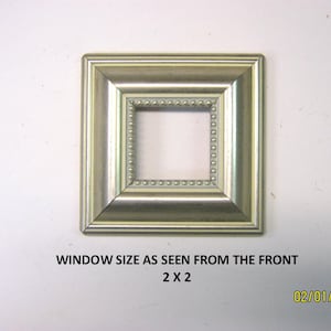 May include: Square picture frame with a silver finish and a beaded inner border. The frame's window size is 2 x 2 inches. The frame is on a white background. Text on the image reads "WINDOW SIZE AS SEEN FROM THE FRONT 2 X 2".