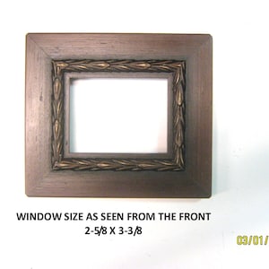 May include: A square, brown picture frame with a decorative gold-colored inner border. The frame's window size is 2-5/8 x 3-3/8 inches. The text "WINDOW SIZE AS SEEN FROM THE FRONT" is visible. The date 03/01/2026 is also visible.