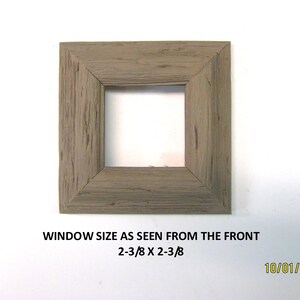 May include: Square wooden frame with a weathered gray finish. The window size is 2-3/8 x 2-3/8 inches. The text on the image reads: WINDOW SIZE AS SEEN FROM THE FRONT 2-3/8 X 2-3/8.