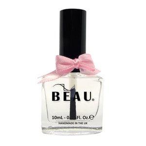May include: A clear glass bottle with a black cap and a pink bow. The bottle is labelled "BEAU" and "10mL - 0 Fl. Oz. e" and "HANDMADE IN THE UK".