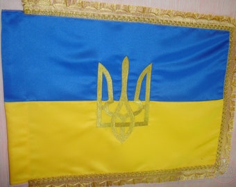 Ukrainian national flag made of satin with an embroidered gold trident and fringe. A souvenir gift to a patriot of Ukraine