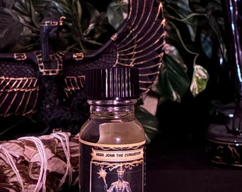 Könnte beinhalten: Eine durchsichtige Glasflasche mit schwarzem Verschluss, die eine helle Flüssigkeit enthält. Das Etikett zeigt den Text "HIGH JOHN THE CONQUEROR" über einer Abbildung einer in Roben gekleideten Figur mit Stab und weiterem Text.