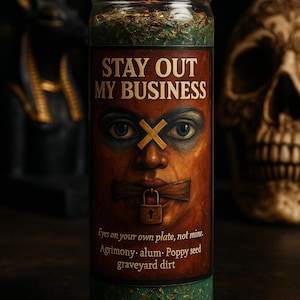 May include: A lit jar candle with the text "STAY OUT MY BUSINESS" and a painted face with a taped mouth and crossed-out eyes. The candle has a green and brown base and contains herbs. The text "Eyes on your own plate, not mine" is also visible.