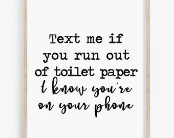 May include: A printable wall art design with a humorous quote: "Text me if you run out of toilet paper I know you're on your phone".