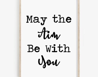 May include: A black and white printable wall art print with the text "May the Aim Be With You".
