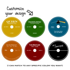 Puede incluir: Seis dise&ntilde;os diferentes de discos de vinilo con varios artistas y t&iacute;tulos de &aacute;lbumes. Los dise&ntilde;os incluyen Queen, Elvis Presley, The Beatles, Pink Floyd, Amy Winehouse y un dise&ntilde;o gen&eacute;rico de "Artista favorito". Cada dise&ntilde;o presenta el nombre del artista, el t&iacute;tulo del &aacute;lbum y el a&ntilde;o de lanzamiento.