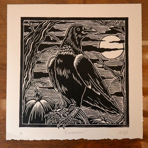 May include: Black and white woodcut print of a raven perched on a branch with pumpkins in the foreground and a full moon in the background. The print is titled "Ravenwood".