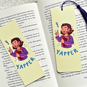 Op de afbeelding: Twee gele bladwijzers met een cartoonillustratie van een persoon die een boek vasthoudt. De tekst "Yapper" staat in blauwe letters op beide bladwijzers.