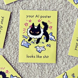 Op de afbeelding: Een rechthoekige gele sticker met een zwarte kat met een witte kanten kraag, staand tussen verspreide blauwe papiersnippers. De tekst your AI poster looks like shit staat in zwarte letters, omringd door kleine roze sterretjes.