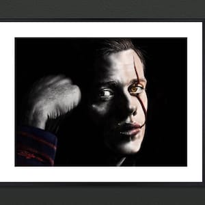 May include: A black and white portrait of a person with a red slash across their face. The person has a serious expression and is looking to the right. The background is black.