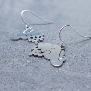 May include: A pair of silver dangle earrings featuring a cloud design. The earrings have a simple hook closure.