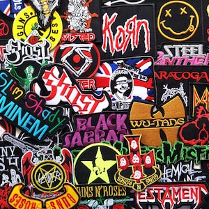 May include: A collection of embroidered patches featuring band logos and names, including "Korn," "Black Sabbath," "Guns N' Roses," and "Eminem." The patches are in various colors and designs, with text and imagery.
