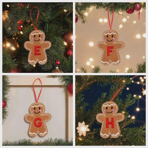 May include: A brown felt gingerbread person ornament featuring a red embroidered letter E, F, G, or H on the chest, white stitched details, pink cheeks, and a red ribbon loop for hanging. The ornament has a smiling face and white icing accents.