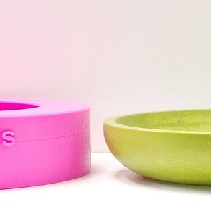 May include: A pink silicone mould for making a bowl, with the words "Devon Moulds" embossed on the side, next to a green ceramic bowl.