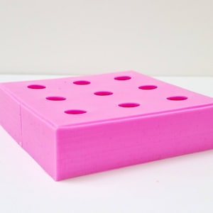 May include: Pink silicone mold with 10 round cavities. The mold is designed for making small treats or crafts.