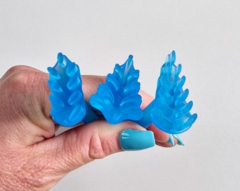 May include: Three blue plastic golf tee markers shaped like a stylized leaf.