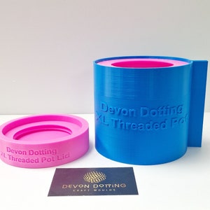 May include: A blue and pink silicone mold for making concrete pots. The mold is labeled "Devon Dotting XL Threaded Pot" and the lid is labeled "Devon Dotting XL Threaded Pot Lid".