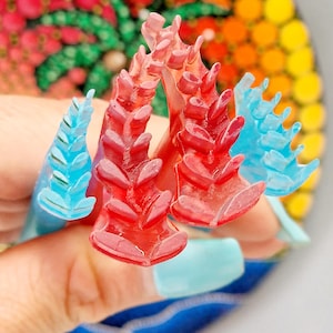 Może przedstawiać: Dwa czerwone i dwa niebieskie narzędzia do tworzenia kropek. Narzędzia są wykonane z tworzywa sztucznego i mają kształt liścia.