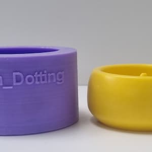 Puede incluir: Un molde de silicona morado y un portavelas amarillo. El molde tiene el texto "Devon_Dotting" en el lateral.
