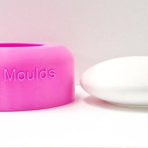 Puede incluir: Un molde de silicona rosa con el texto "Devon Moulds" en el lateral, junto a un objeto redondo blanco.