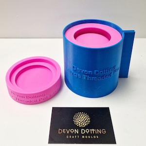 May include: A blue silicone mold for making a large threaded pot lid. The mold is in two pieces, a base and a lid. The mold is labeled "Devon Dotting Large Threaded Pot Lid".