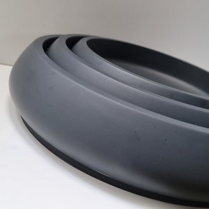 Pode incluir: Um conjunto de três tigelas cinzas encaixáveis. As tigelas são feitas de um material liso e durável e são perfeitas para servir petiscos, molhos ou saladas.