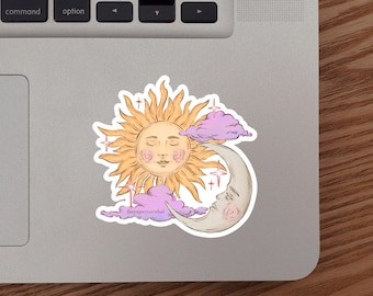 May include: A sticker featuring a celestial design with a smiling sun, a crescent moon with a face, and pink clouds. The sun is yellow with pink cheeks and the moon is a light beige color. The text "thepaperroarwhal" is at the bottom.