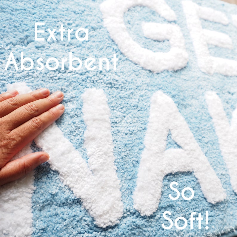 May include: A blue bath mat with the words "Get Away" in white fluffy letters. The mat is described as "Extra Absorbent" and "So Soft!"