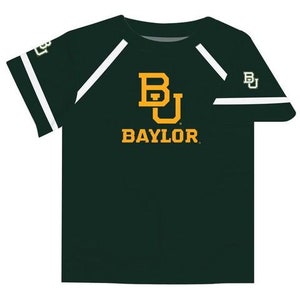 May include: A green short-sleeved t-shirt with white trim on the sleeves and a gold Baylor University logo on the front. The logo features the letters "BU" with the word "Baylor" underneath.