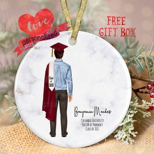 May include: A white round ceramic ornament with a marble pattern. A watercolor illustration of a person wearing a graduation cap and gown is on the ornament. The text "Class of 2021" is on the gown. The text "Benjamin Mendes, Columbia University, Doctor of Pharmacy, Class of 2021" is on the ornament.