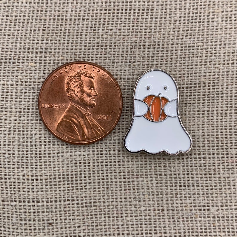 Peut inclure: Un fant&ocirc;me blanc avec un masque de citrouille. Le fant&ocirc;me porte une &eacute;pingle en m&eacute;tal argent&eacute; et mesure environ la taille d'une pi&egrave;ce de monnaie fran&ccedil;aise.