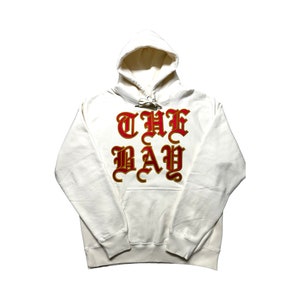 May include: A white hoodie with a red and gold "THE BAY" graphic printed on the front.