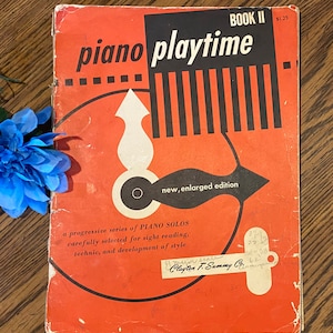 May include: A red and black book titled "piano playtime" with the words "BOOK II" and "new, enlarged edition" printed on the cover. The book is a progressive series of piano solos, carefully selected for sight reading, technic, and development of style. The book is published by Clayton F. Summy Co.