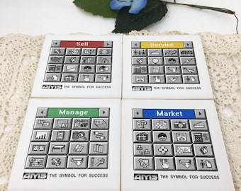May include: Four white ceramic coasters with black and white icons depicting business concepts. Each coaster has a colored title bar: Sell (red), Service (yellow), Manage (green), and Market (blue). The coasters feature the text "AMS The Symbol for Success".