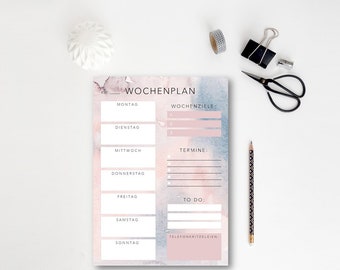 May include: A weekly planner with a watercolor background in shades of pink and blue. The planner has sections for daily tasks, weekly goals, appointments, to-do list, and phone calls.