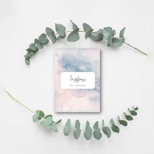 May include: A small, rectangular notebook with a watercolor design in shades of pink and blue. The cover features a white rectangular label with the German words "Impfpass" and "Vor- Zuname" in black script. Eucalyptus branches frame the notebook.