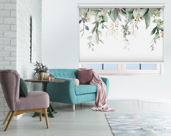 May include: A teal blue sofa with a pink throw blanket and a white window blind with a watercolor floral design. The blind is partially rolled up, revealing a view of a white brick wall.