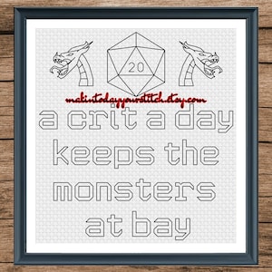 Op de afbeelding: Zwart-witte kruissteekpatroon met twee draken die een 20-zijdige dobbelsteen flankeren. De tekst luidt "a crit a day keeps the monsters at bay".