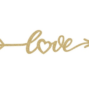 May include: Gold glitter arrow with the word "love" written in cursive with a heart in the middle of the word.