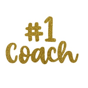 May include: Gold glitter #1 Coach text on a white background.