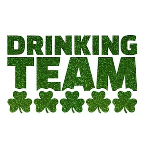 May include: A graphic design with the words "DRINKING TEAM" in large, glittery green letters. Below the text are five green shamrock symbols, all on a white background.