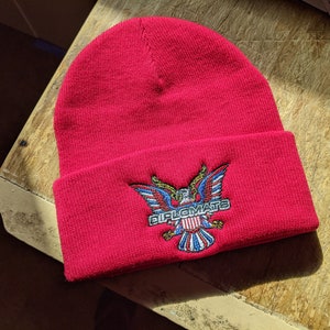 May include: Red knit beanie with a white and blue embroidered eagle and the text "DIPLOMATS".