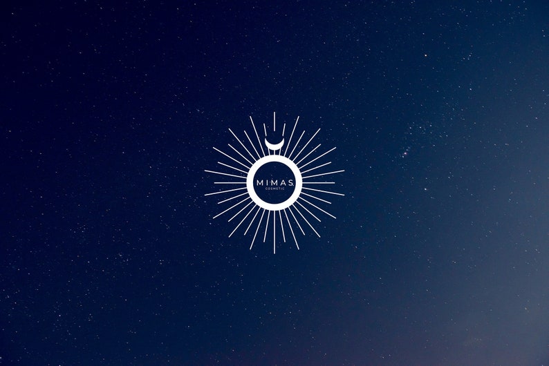 Puede incluir: Logotipo blanco sobre fondo azul oscuro con efecto de noche estrellada. El logotipo presenta un dise&ntilde;o de sol con una luna creciente y el texto "MIMAS COSMETIC" en un marco circular.