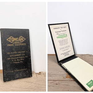 May include: Vintage black notepad with the text "TONCAN IRON CULVERTS" in gold lettering. The notepad is open, revealing graph paper and additional text. The cover also includes the Tri-State Culvert & Machinery Co. address.