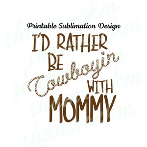 Peut inclure: Sur fond blanc, texte marron : "Printable Sublimation Design" en haut. En dessous, "I'D RATHER BE Cowboyin' WITH MOMMY". Le mot "Cowboyin'" est stylisé avec une corde.